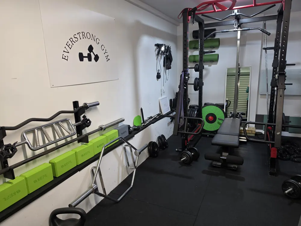 The Everstrong Gym in Ealing: the power rack, plates and the Everstrong sign