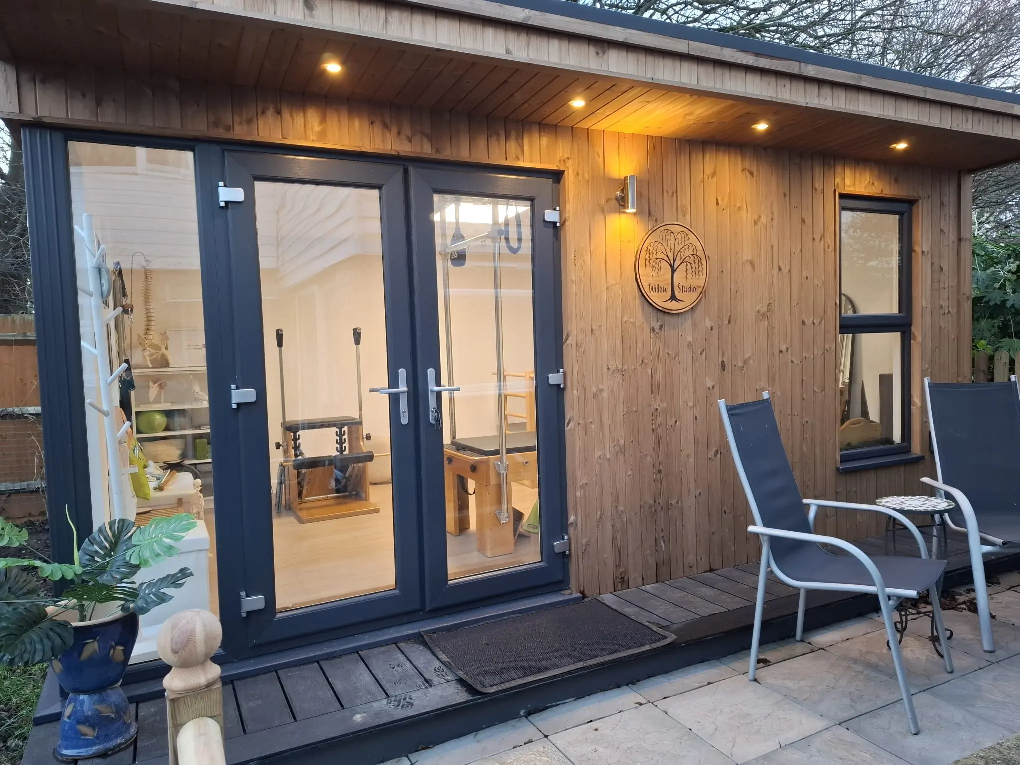 The Willow Studio, Liz Shaw's garden Pilates studio in West Ealing, lit up at dusk