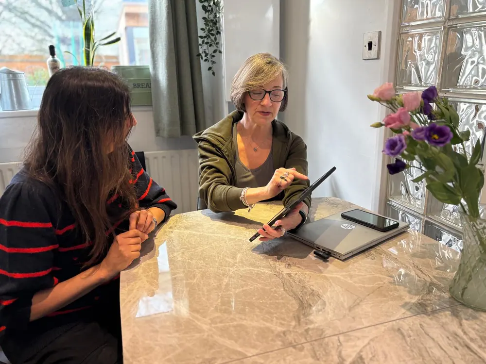 Liz Shaw talking through a plan with a client at the table